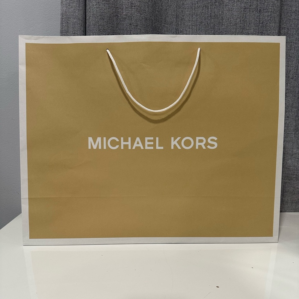 Empty Michael Kors Gold Luxury paper shopping bag.